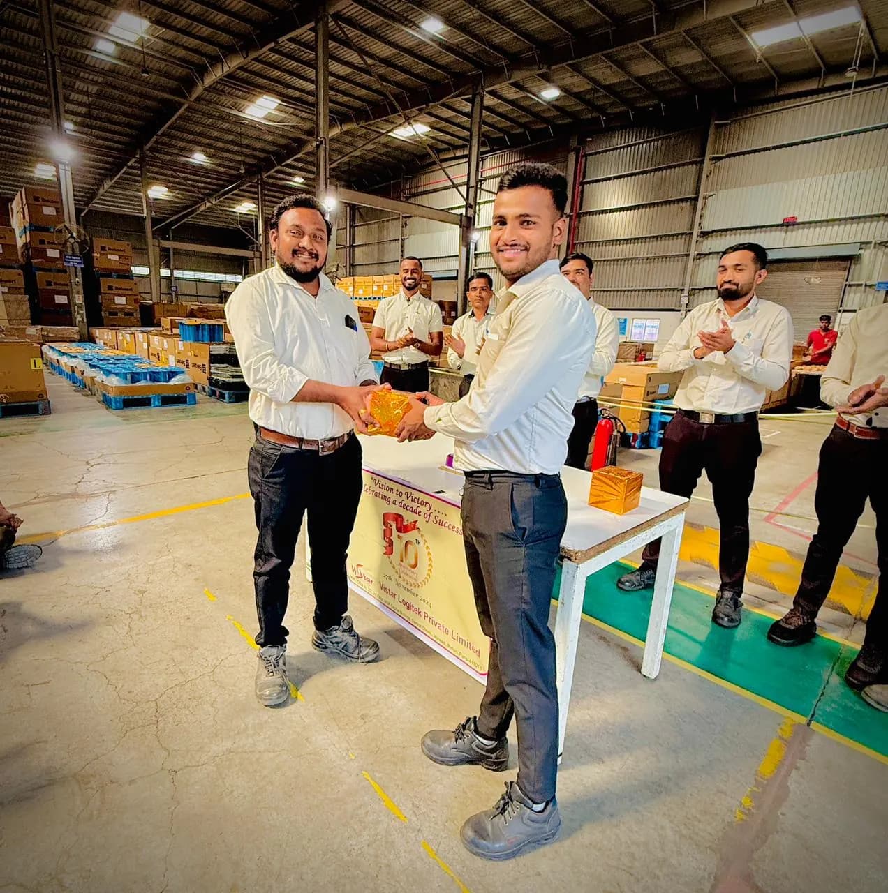 A Vistar colleague receiving a recognition award on the warehouse floor
